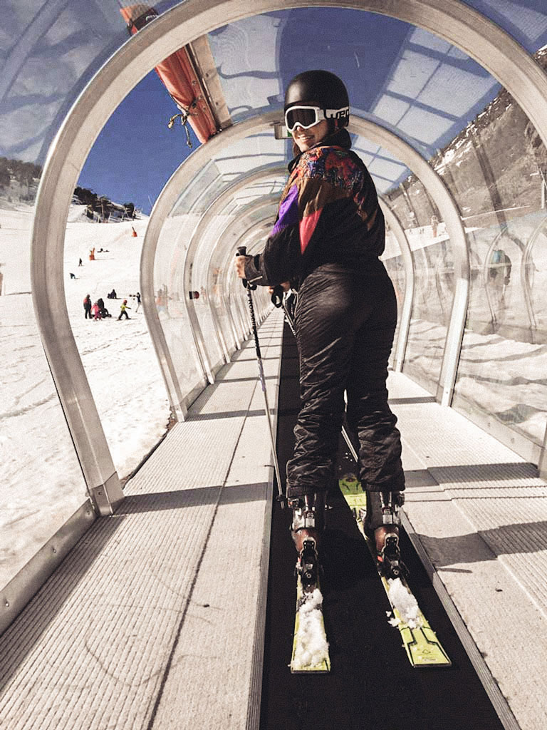 A young woman skiing through a moving tunnel in Andorra